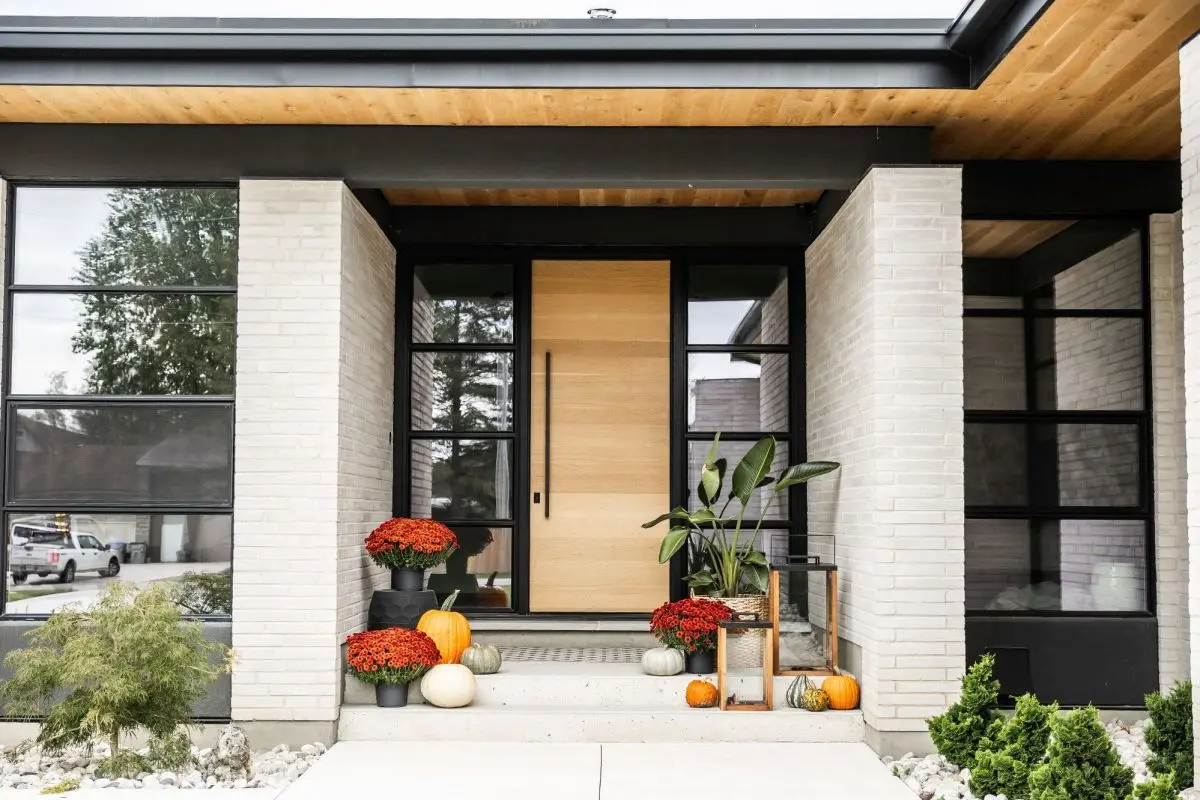 Modern front door design by Homestead Woodworks, featuring natural wood and sleek glass panels for a contemporary entrance